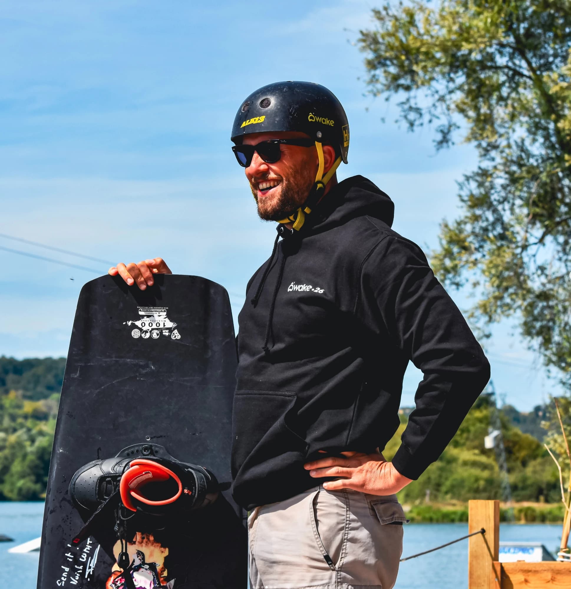 Sweat à capuche noir brodé O'Wake Gamaches porté au bord du plan d'eau